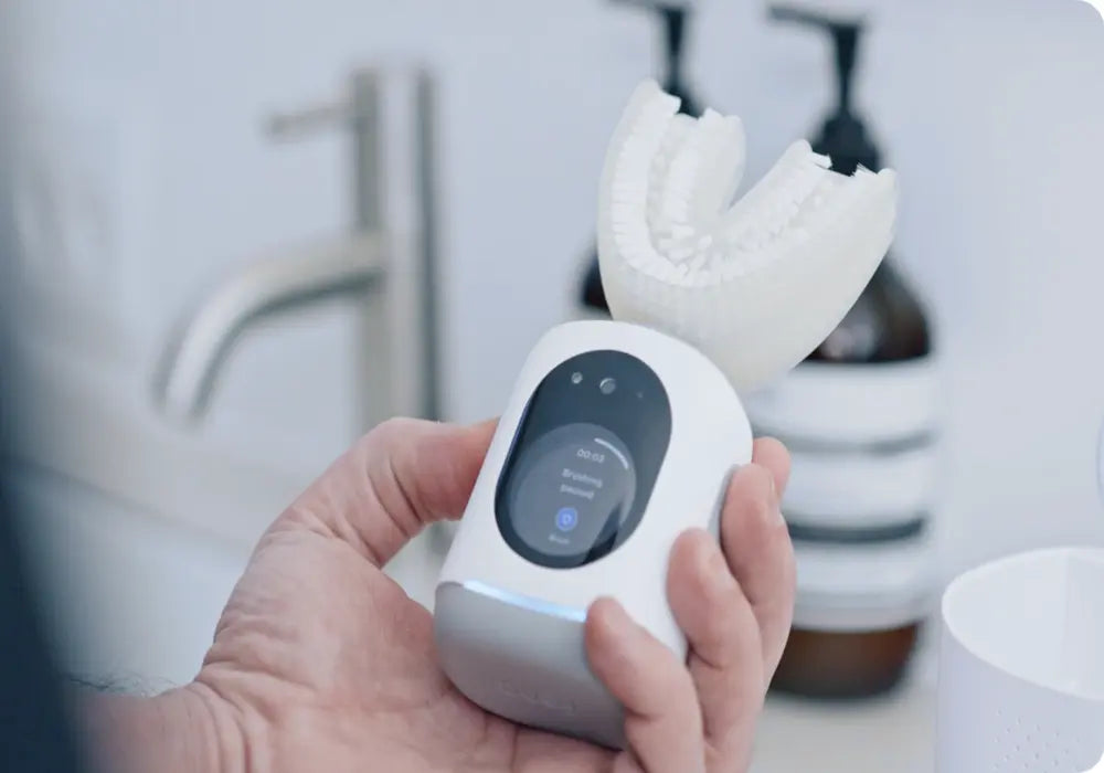 AI-powered toothbrush held in hand with a digital screen displaying brushing session details.