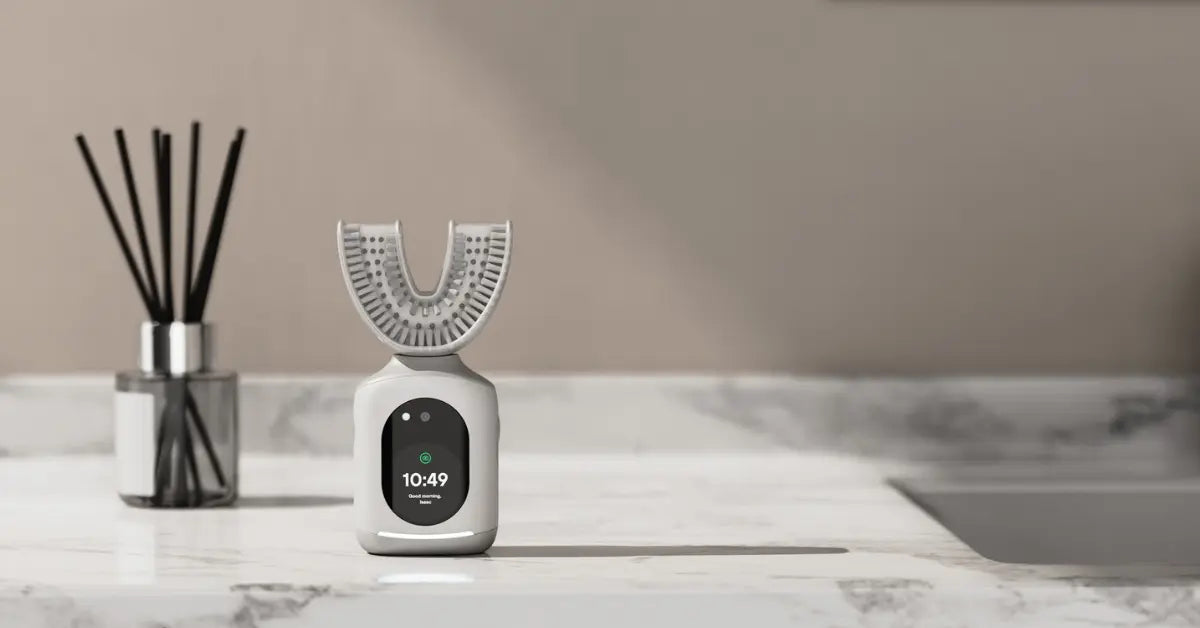 Smart toothbrush with U-shaped design and digital display on a marble bathroom counter.