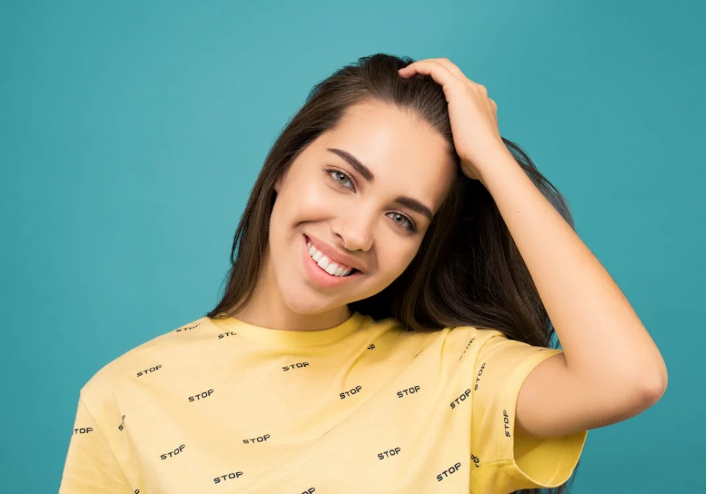 Advantages of U-shaped toothbrushes represented by a happy woman with healthy teeth, smiling confidently.