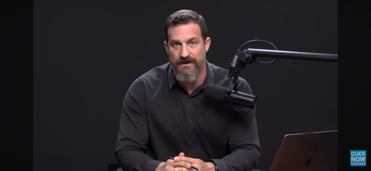 Bearded speaker at a podcast microphone discussing oral health and brain health connections.