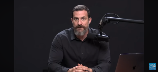 Podcast host speaking into a studio microphone beside a laptop, discussing oral health timing.