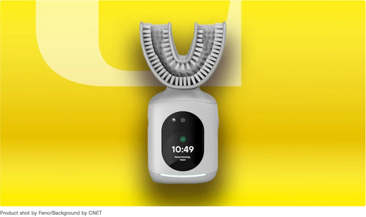 U-shaped smart toothbrush with bristled mouthpiece and touchscreen base on a yellow background.