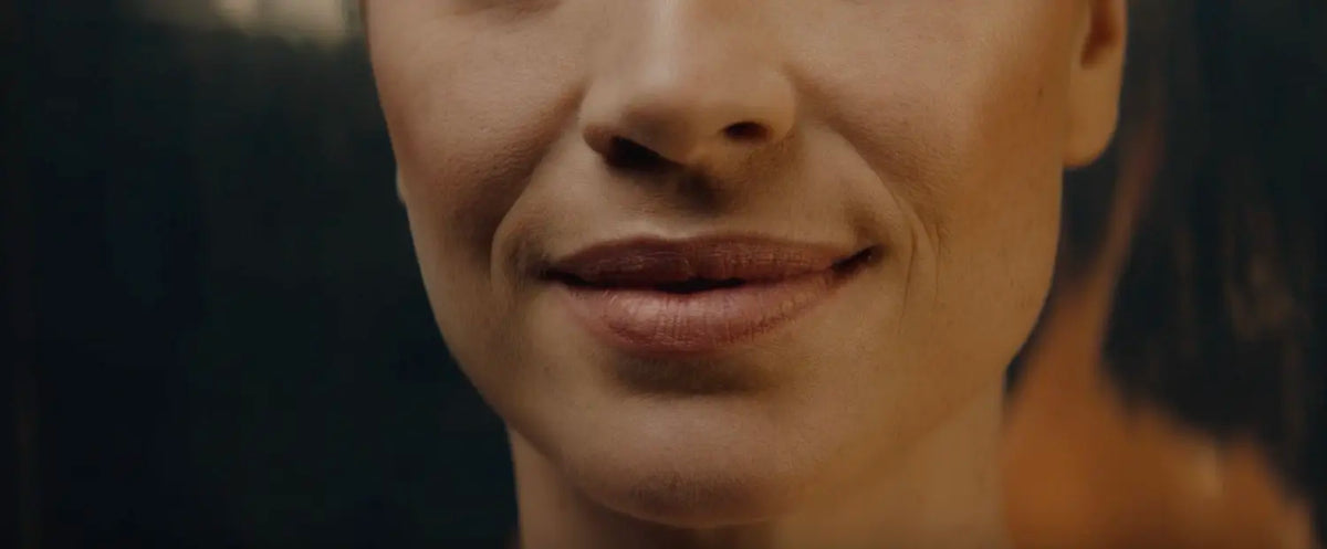 Close-up of a person's lower face showing subtle smile lines around the mouth.