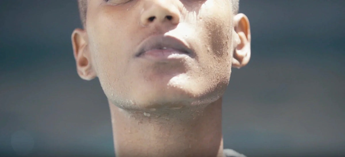 Close-up of a person's lower face and jawline showing defined chin and clenched jaw tension.