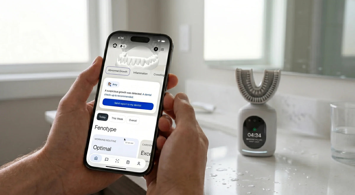 Hands holding a phone showing the Feno app's oral health report beside a U-shaped smart toothbrush.