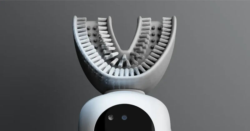 Close-up of a white U-shaped electric toothbrush head with dense nylon bristles.