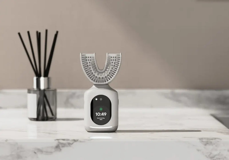 Smart dental devices displayed on a marble countertop with real-time health tracking screen.
