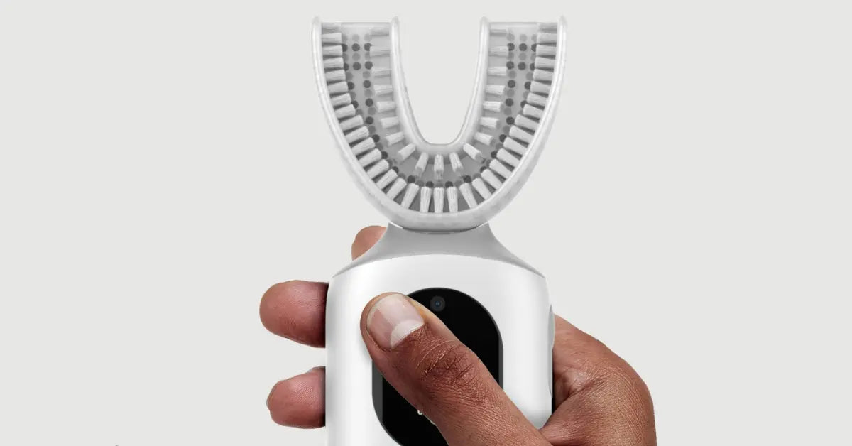 Smart toothbrush technology demonstrated by a hand holding an AI-powered toothbrush with a U-shaped head.