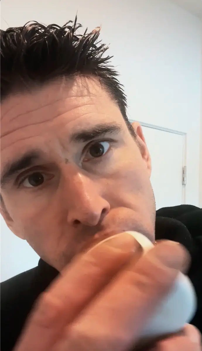 Person using a white U-shaped smart toothbrush mouthpiece to brush their whole mouth.