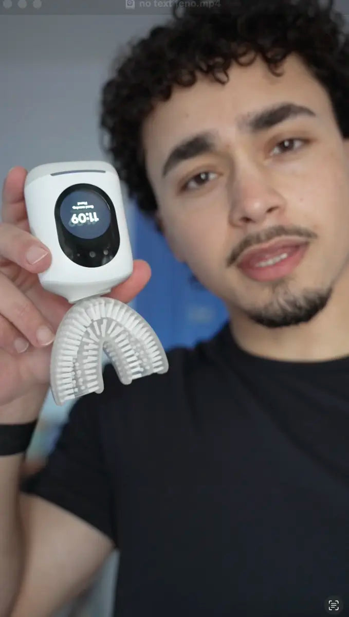 Person holding a Feno u-shaped smart toothbrush with digital display and silicone mouthpiece.