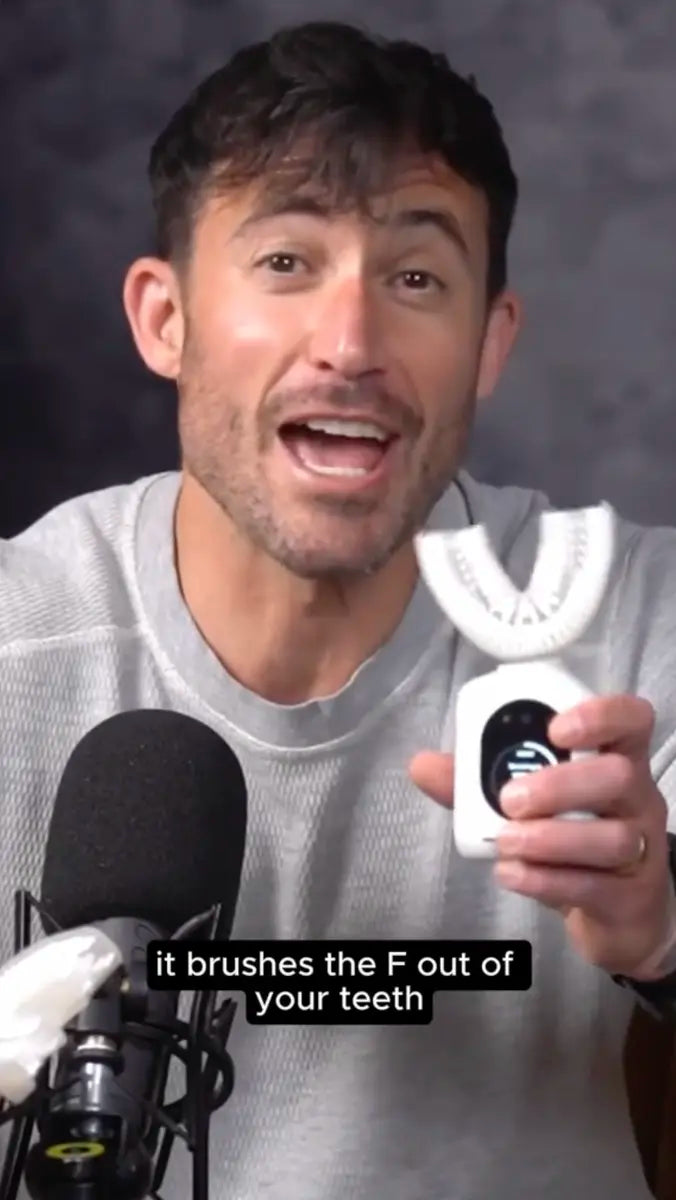 Person holding a white U-shaped electric toothbrush to camera during a video review.